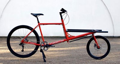 Röd cykel med lastflak framför styret