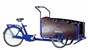 En blå trehjulig lastcykel med låda fram.