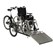 En trehjulig cykel med rullstolsramp fram. På ramen står en rullstol.